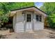 Charming outbuilding with white siding, a windowed door, and a classic outdoor lantern fixture at 7831 W 109Th Ave, Westminster, CO 80021