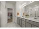 Bright bathroom with double sinks, granite countertops, and a walk-in closet at 12580 Boggs St, Parker, CO 80134
