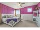 Bright bedroom with plush bedding, purple accent wall, and modern decor at 12580 Boggs St, Parker, CO 80134
