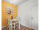 Cozy dining area with a white table set against a vibrant yellow wall with a floral painting at 12580 Boggs St, Parker, CO 80134