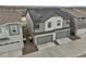 Side exterior view of a modern two-story home with a two-car garage and solar panels on the roof at 12580 Boggs St, Parker, CO 80134