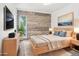 Modern bedroom with a stylish accent wall, neutral tones, and a large window for natural light at 3663 S Sheridan Blvd # H15, Denver, CO 80235