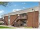 A red brick apartment building with stairwells leading to upper units and well-maintained landscaping at 3663 S Sheridan Blvd # H15, Denver, CO 80235