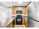 Functional kitchen featuring wood cabinets, a black appliance suite, and laminate countertops at 3663 S Sheridan Blvd # H15, Denver, CO 80235