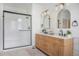 Modern bathroom with double vanity, stylish lighting, and a sleek, glass-enclosed shower at 7410 Winter Berry Ln, Castle Pines, CO 80108