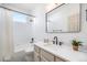 Clean, white bathroom featuring a vanity, bathtub with shower, and dark fixtures at 7410 Winter Berry Ln, Castle Pines, CO 80108