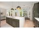 Kitchen featuring a large island, green cabinetry, modern lighting, and lots of windows at 7410 Winter Berry Ln, Castle Pines, CO 80108