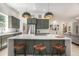 Bright kitchen features an island with quartz countertops, modern lighting, and wooden stools at 7410 Winter Berry Ln, Castle Pines, CO 80108