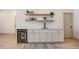 Wet bar area with a beverage cooler, sleek sink, and floating shelves for storage at 7410 Winter Berry Ln, Castle Pines, CO 80108