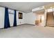 Unfinished basement features neutral carpet, white walls, and staircase access at 90 S Fraser Cir, Aurora, CO 80012