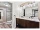 Bathroom with double sinks, walk-in shower, and modern vanity at 90 S Fraser Cir, Aurora, CO 80012