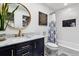 Bathroom features a modern vanity with gold accents, tile backsplash, and shower with patterned curtain at 90 S Fraser Cir, Aurora, CO 80012