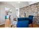 Inviting dining area with stone accent wall, wood floors, and views into the updated kitchen at 90 S Fraser Cir, Aurora, CO 80012