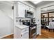 Modern kitchen featuring stainless steel appliances, white cabinets, and a skylight at 90 S Fraser Cir, Aurora, CO 80012