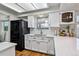 Charming kitchen with white cabinets, quartz countertops, a black refrigerator, and wood floors at 90 S Fraser Cir, Aurora, CO 80012