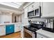 Modern kitchen featuring stainless steel appliances, white cabinets, and a skylight at 90 S Fraser Cir, Aurora, CO 80012