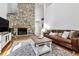 Living room featuring a stone fireplace, hardwood floors, and comfortable seating at 90 S Fraser Cir, Aurora, CO 80012