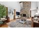 Cozy living room featuring a stone fireplace, hardwood floors, and large windows at 90 S Fraser Cir, Aurora, CO 80012