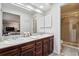 The main bathroom features double sinks, a walk-in shower, and dark wood cabinetry at 90 S Fraser Cir, Aurora, CO 80012