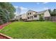 Expansive backyard featuring lush grass, mature trees, and a wooden fence at 5337 S Ukraine Way, Aurora, CO 80015
