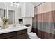 Bright bathroom featuring a vanity, sink, toilet, and coordinated shower curtain at 5337 S Ukraine Way, Aurora, CO 80015