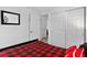 View of a bedroom with a red buffalo check comforter, door leading to another room, and closet at 5337 S Ukraine Way, Aurora, CO 80015