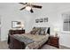 A cozy main bedroom featuring a ceiling fan, brown carpet, and earth-toned bedding with decorative pillows at 5337 S Ukraine Way, Aurora, CO 80015
