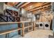 Basement laundry area with exposed wood ceiling, shelving and storage cabinets at 3257 S Geneva St, Denver, CO 80231