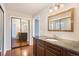 Spacious bathroom featuring a granite-topped vanity, mirrored closet doors, and neutral decor at 3257 S Geneva St, Denver, CO 80231