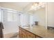 Bathroom featuring a large vanity with granite countertop, a shower/tub, and a decorative mirror at 3257 S Geneva St, Denver, CO 80231