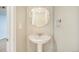 Cozy bathroom featuring a pedestal sink and decorative mirror, offering a clean and simple design at 3257 S Geneva St, Denver, CO 80231