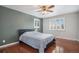 Charming bedroom with hardwood floors, a ceiling fan, white shutters, and a calming green accent wall at 3257 S Geneva St, Denver, CO 80231