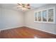 Bright bedroom with hardwood floors, a ceiling fan, and a window with white shutters, offering a clean, spacious feel at 3257 S Geneva St, Denver, CO 80231