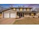 Two-story home with brick and siding, two-car garage, and manicured lawn at 3257 S Geneva St, Denver, CO 80231