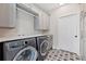 Well-equipped laundry room with modern washer and dryer, stylish tile floor, and ample storage at 1721 S Jackson St, Denver, CO 80210