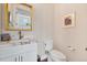 Charming powder room features marble countertop, brass fixtures, and a stylish gold-framed mirror at 1721 S Jackson St, Denver, CO 80210