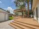 Wooden deck and paver patio lead to the fenced in yard, with a wooden pergola and built-in tree at 2155 S Emerson St, Denver, CO 80210