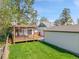 Green backyard featuring a multi-level deck with pergola, spacious lawn, and convenient storage shed at 2155 S Emerson St, Denver, CO 80210