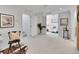 Bright basement hallway featuring white walls, carpet, wall art and an open door to a bedroom at 2155 S Emerson St, Denver, CO 80210