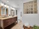 Bright bathroom features double sinks, granite countertops, and decorative glass block window for natural light at 2155 S Emerson St, Denver, CO 80210