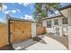 View of the detached garage with custom wood doors and brick walls with side-yard patio access at 2155 S Emerson St, Denver, CO 80210