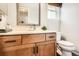 Bathroom vanity with wood cabinets, light countertops, chrome hardware, and a toilet on a wood floor at 746 Poppywood Dr, Highlands Ranch, CO 80126