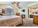 Bedroom with carpet floor, bed, chest, large window, ceiling fan, and neutral wall paint with ensuite bathroom at 746 Poppywood Dr, Highlands Ranch, CO 80126