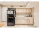 Basement kitchenette with white countertops, cabinets, and black appliances at 746 Poppywood Dr, Highlands Ranch, CO 80126