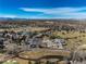 Stunning aerial view showcases the golf course with clubhouse and the expansive residential area and blue sky at 22 Wedge Way, Littleton, CO 80123