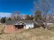 Expansive backyard featuring a charming covered patio, and mature trees under a clear blue sky at 22 Wedge Way, Littleton, CO 80123