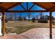 Covered patio with a vaulted ceiling leading to a spacious landscaped backyard with mature trees at 22 Wedge Way, Littleton, CO 80123