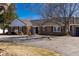 Charming front exterior view showcasing brick facade and black shutters with a circular driveway at 22 Wedge Way, Littleton, CO 80123