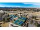 Aerial view displays multiple tennis courts surrounded by greenery, creating a recreational haven at 22 Wedge Way, Littleton, CO 80123