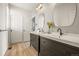 This is a bathroom with dual sinks with dark wood cabinets and wooden floors at 10057 S Shadow Hill Dr, Lone Tree, CO 80124